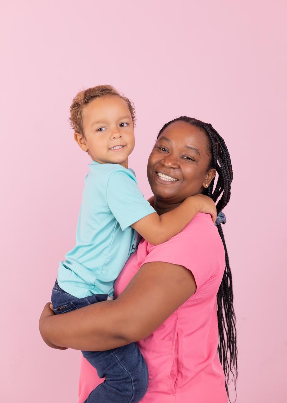Nanny holding a smiling child — Babysitter PRO Punta Cana