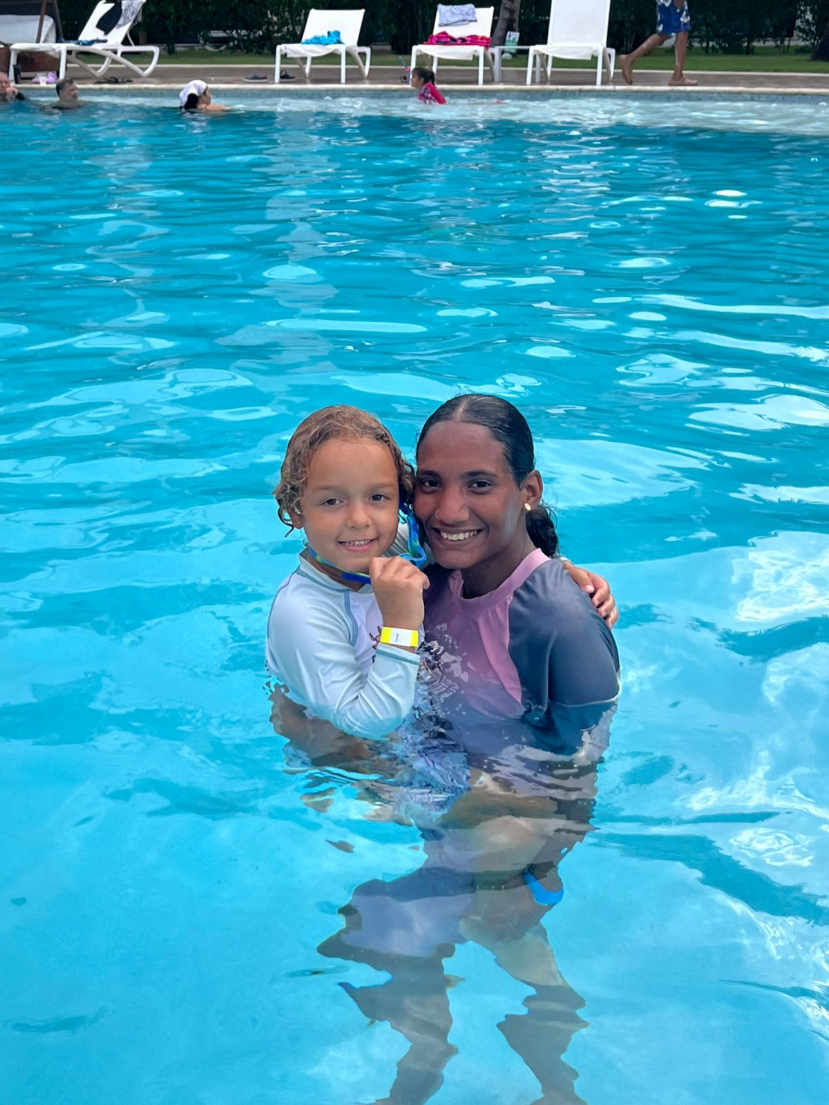 Nanny and child quietly playing poolside